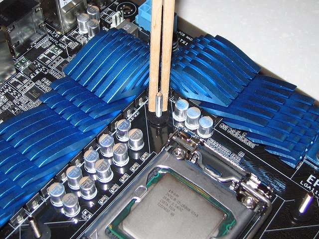 プッシュピン式 CPU クーラー（Scythe グランド鎌クロス リビジョンB SCKC-2100）をネジ式に変更するため、Scythe ユニバーサルリテンションキット3 SCURK-3000 付属 バックプレートを ASUS P8Z68-V PRO/GEN3 に装着、バックプレートネジ穴に「バックプレート取り付けネジ（Intel）」を挿入、バックプレートを手で押さえたままマザーボードを反対側に向きを変更、ネジ山に「バックプレート落下防止用ゴム（Intel）」を取り付け、VRM ヒートシンク側の「バックプレート落下防止用ゴム（Intel）」は手で押し込みにくいため割り箸で押し込んだところ